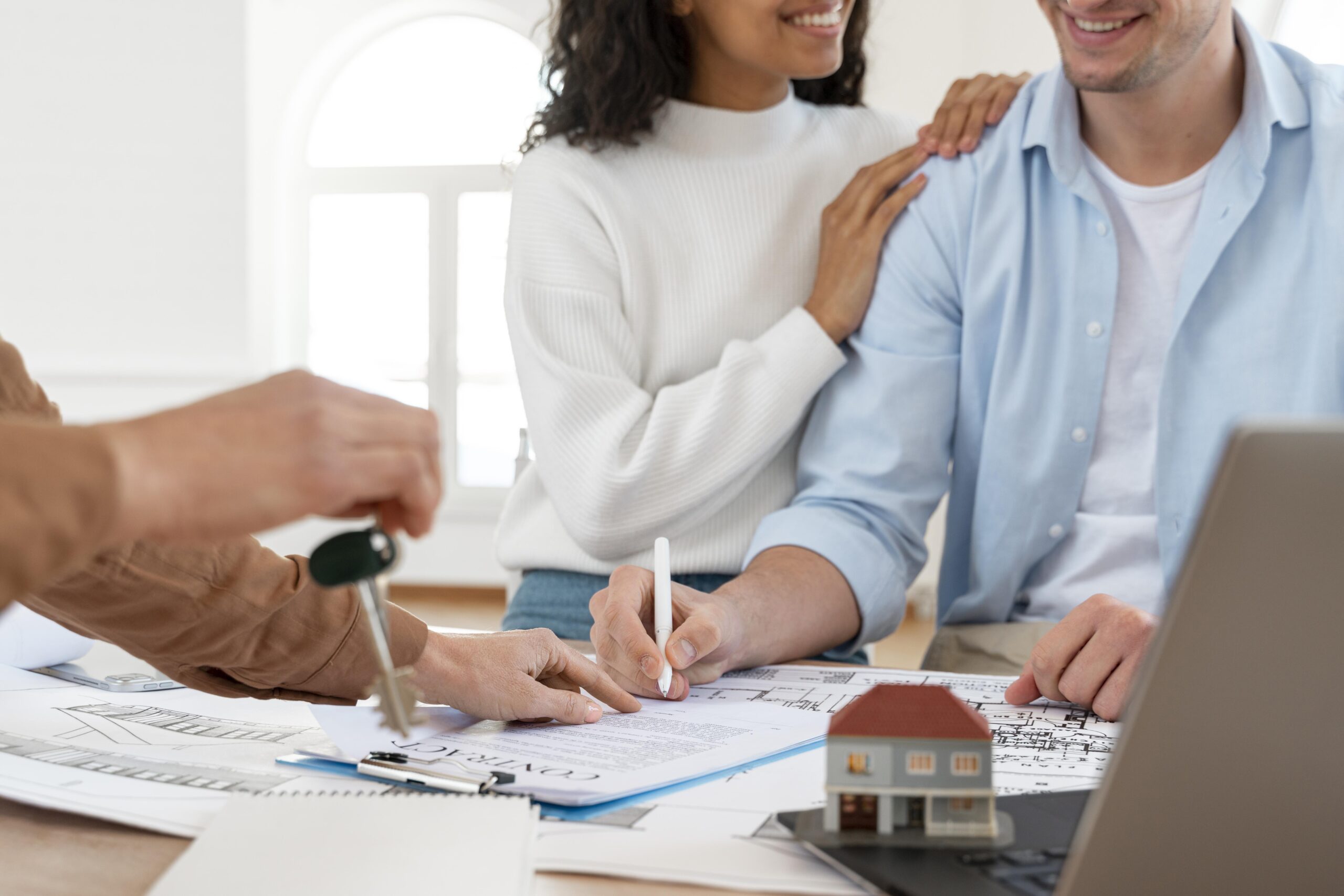 smiley couple signing contract new house scaled - Direito Imobiliário